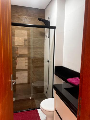 uma casa de banho com um WC e uma cabina de duche em vidro. em Apartamento Ingleses para Casal 102 em Florianópolis