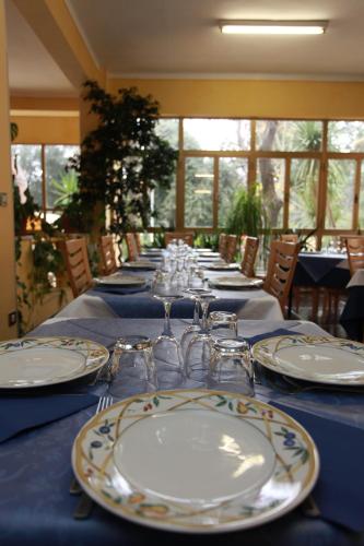 a long table with plates and wine glasses on it at Hotel Athena in Pesaro