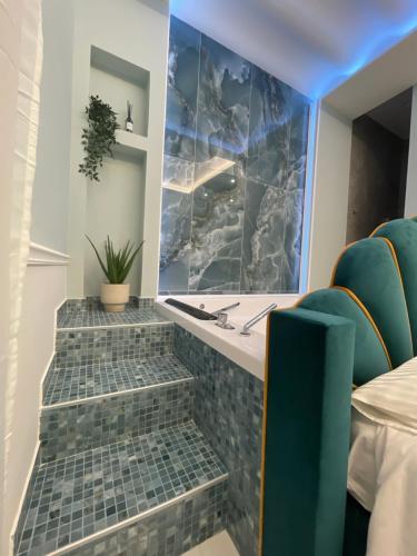 Baño con 3 escaleras y sillas verdes en Sunny Suite Napoli, en Nápoles