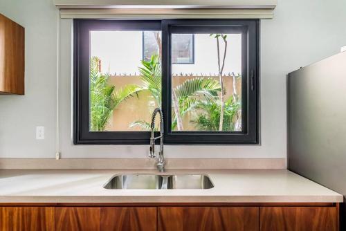 eine Küchenspüle mit einem Fenster darüber in der Unterkunft Arcadia Tulum by The Spot Rentals in Tulum