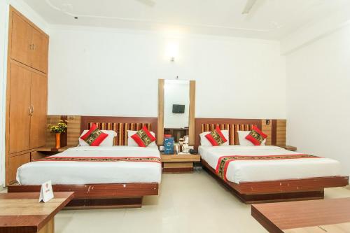 1 dormitorio con 2 camas y espejo en OYO Hotel Indiana Near Gomti Riverfront Park, en Vibhuti Khand
