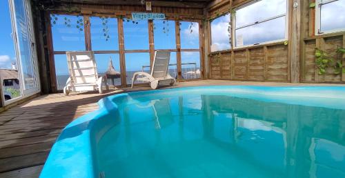 a swimming pool in a house with a view of the ocean at NewViejoBlanco in Punta Del Diablo