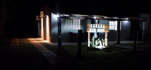 un edificio de noche con un cartel en la oscuridad en Cabaña Nde Roga en Colonia Carlos Pellegrini