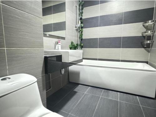 La salle de bains est pourvue d'une baignoire, de toilettes et d'un lavabo. dans l'établissement H.E Homestay, à Johor Bahru