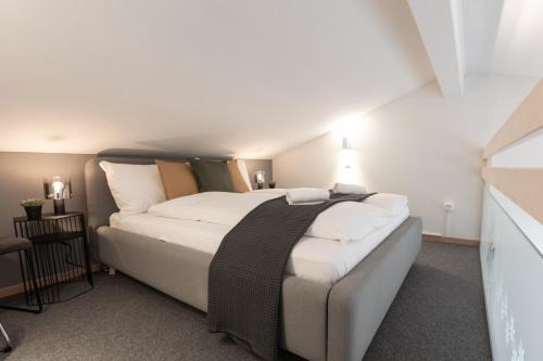 a bedroom with a large bed with white sheets at Spirit Apartments Suites in Brienz