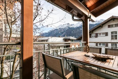 a balcony with a table and chairs and a mountain at Spirit Apartments Suites in Brienz