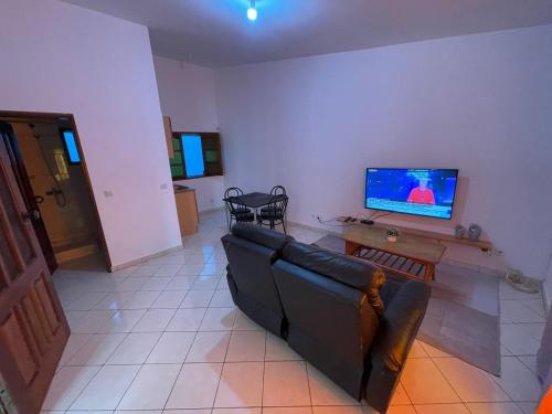 Casa Cor de Rosa في برايا: غرفة معيشة مع أريكة وتلفزيون بشاشة مسطحة
