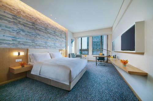 a hotel room with a large bed and a flat screen tv at Holiday Inn Express Nantong Textile City by IHG in Tongzhou