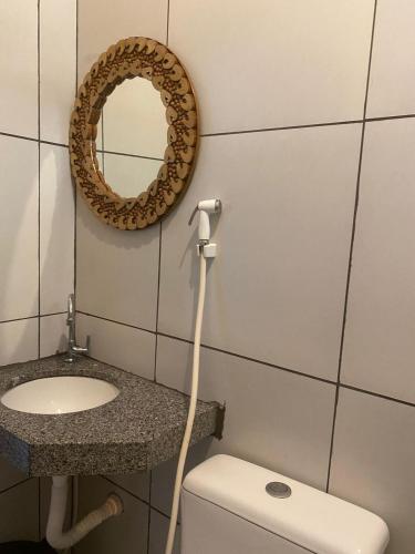 a bathroom with a sink and a toilet and a mirror at Estrela dos Lençóis in Atins
