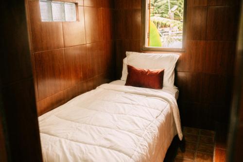 a small bed in a small room with a window at Navalia Villa Bedugul in Bedugul