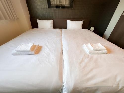 a bed with two towels sitting on top of it at Ostay Kyoto west hotel APT in Kyoto