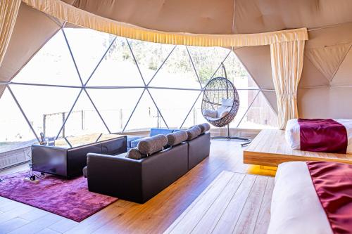 a living room with a large window in a tent at glampark ACONCAGUA RESORTS in Minami Aso