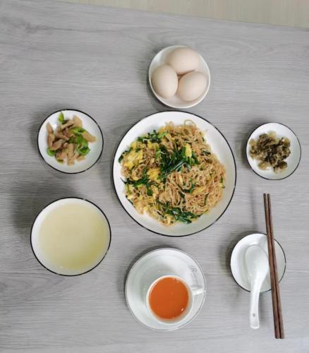a table with plates of food with eggs and other ingredients at Olioinn B&B in Wenchang