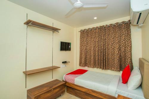 a small bedroom with a bed and a window at Super OYO Flagship Olivia Comforts Near Nexus Mall Koramangala in Bangalore