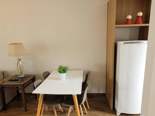 a kitchen with a white table and a white refrigerator at Sobrado com garagem e churrasqueira in Tijucas