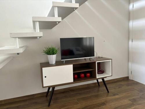 Una sala de estar con un televisor de pantalla plana sobre un soporte. en Sobrado com garagem e churrasqueira, en Tijucas