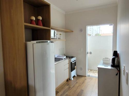 a small kitchen with a refrigerator and a stove at Sobrado com garagem e churrasqueira in Tijucas