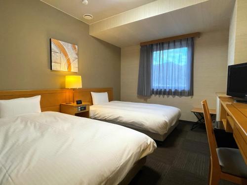 Habitación de hotel con 2 camas y TV en Hotel Route-Inn Tendo, en Tendō