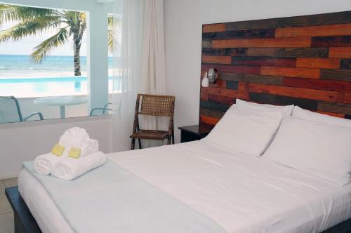 Un dormitorio con una cama blanca con toallas. en Bravo Beach Hotel, en Vieques