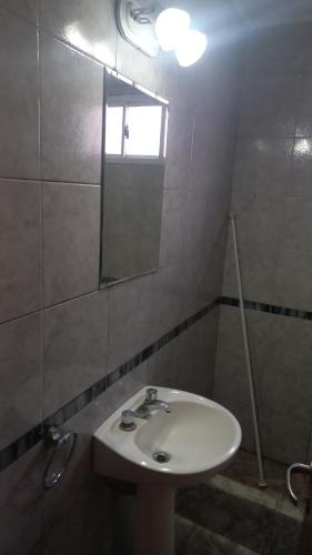 La salle de bains est pourvue d'un lavabo et d'un miroir. dans l'établissement Los 3 ases, à Olavarría