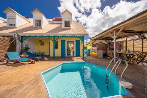 uma casa com piscina em frente a uma casa em Villa Kay Lakansiel, magnifique cocon familial avec piscine em Le Vauclin