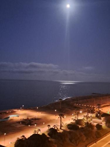 a view of a beach at night with a full moon at Attico Suite spiaggia Bari in Bari