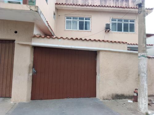 une maison avec deux portes de garage devant elle dans l'établissement Canto do sol, à Cabo Frio