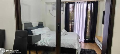 een slaapkamer met een bed en een spiegel bij Elegant 1 bedroom Deluxe Suite Near NAIA in Manilla