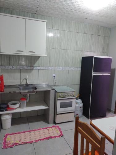 cocina con fregadero y nevera en Residencial Caiobá I, en Matinhos