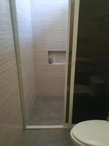 bagno con doccia in vetro e servizi igienici di Fins Pacific Coral Bay 