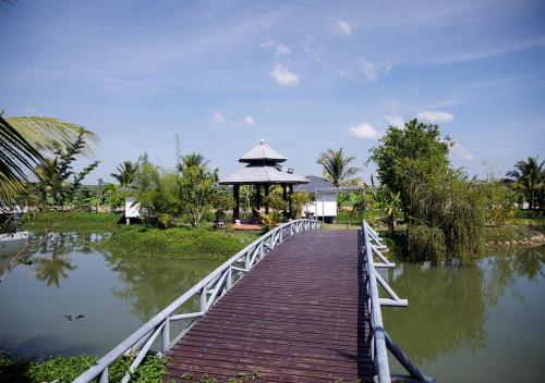 a boardwalk leading to a gazebo over a river at LUA Farmstay in Ba Ria