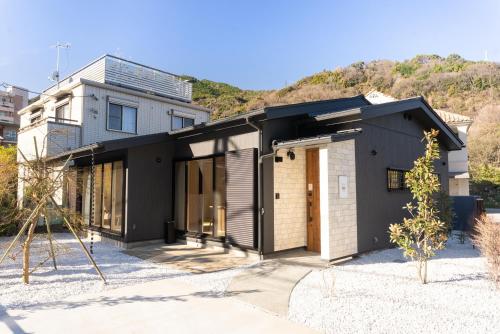 una casa con un exterior blanco y negro en Stagione Hakone Yumoto Villa スタジオーネ箱根湯本VILLA, en Hakone