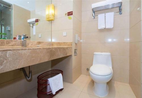 a bathroom with a white toilet and a sink at Vienna International Hotel - Shanghai World Expo Garden in Shanghai