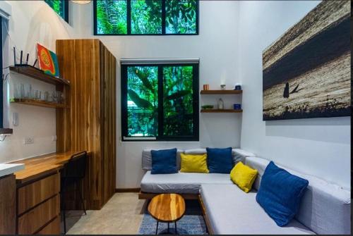 a living room with a couch with yellow and blue pillows at Condo VNV walking distance to the beach in Nosara