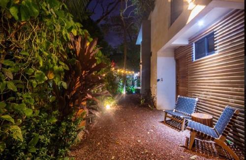 two blue benches sitting next to a building at night at Condo VNV walking distance to the beach in Nosara