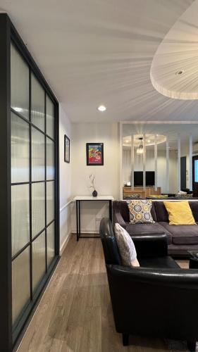 a living room with a couch and a table at Neveu Premier Residence : Ratchada in Bangkok
