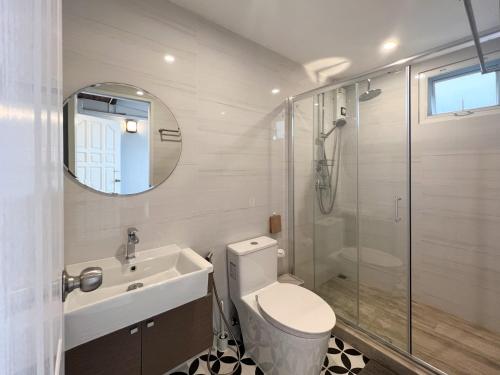 a bathroom with a toilet and a sink and a shower at Neveu Premier Residence : Ratchada in Bangkok