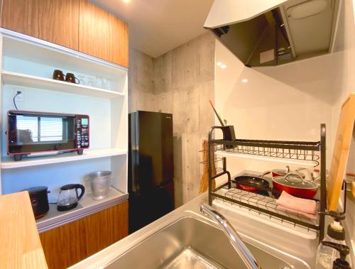 uma pequena cozinha com um lavatório e um frigorífico em さくらや旅館 em Mongawa