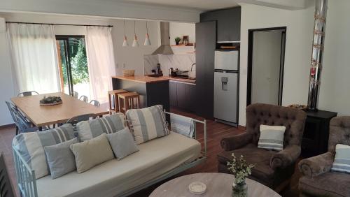 a living room with a couch and chairs and a kitchen at Manantial MAR AZUL in Mar Azul