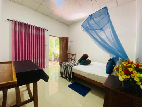 1 dormitorio con cama, mesa y ventana en Priyavimana resort en Habarana