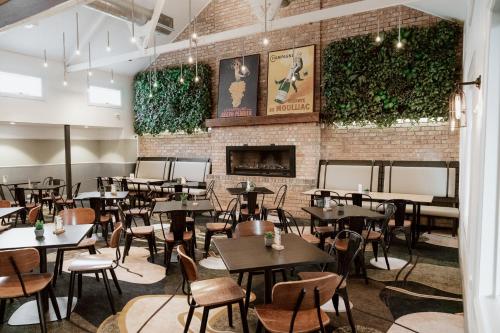 a restaurant with tables and chairs and a brick wall at Sydney Junction Hotel in Hamilton
