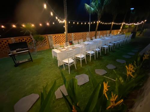a row of tables with white chairs and lights at Emirate Villa Mui Ne in Mui Ne