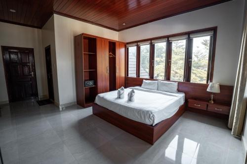 a bedroom with a large bed and a large window at Vang Vieng Garden Resort in Vang Vieng