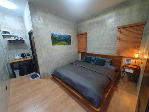 a bedroom with a large bed and a desk at Kedthawa Homestay เฮือนนาวา in Ban Cho Lae