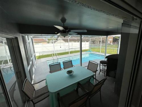 a dining room with a table and a swimming pool at Manatee Oasis Weeki Wachee Family Fun Pool Home in Spring Hill