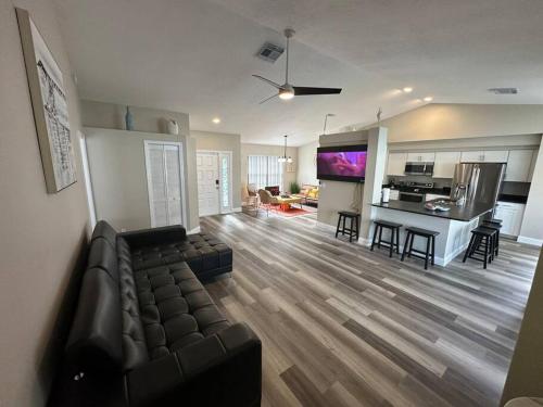 a large living room with a couch and a kitchen at Manatee Oasis Weeki Wachee Family Fun Pool Home in Spring Hill