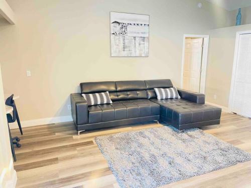 a black leather couch in a living room at Manatee Oasis Weeki Wachee Family Fun Pool Home in Spring Hill