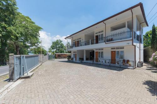 a large white house on a brick driveway at Urbanview Maribaya Lembang Bandung in Bandung