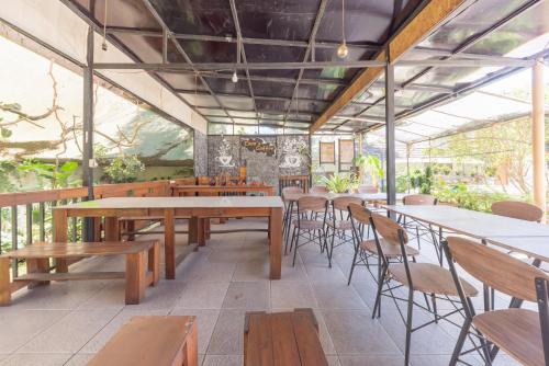 an empty restaurant with wooden tables and chairs at Urbanview Maribaya Lembang Bandung in Bandung