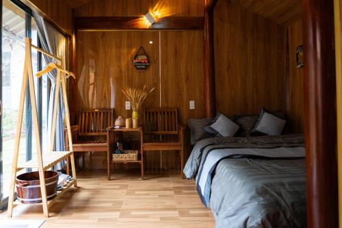sypialnia z łóżkiem w drewnianym pokoju w obiekcie Hoa Cusc Homestay Măng Đen w mieście Kon Von Kla